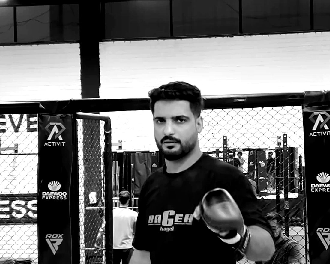 MMA Coach Hassan Muhiuddin in the cage, gloved up